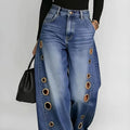 Retro-style wide-leg jeans with metallic eyelets, high-waisted, loose, floor-length fit, gradient eyelets of varying sizes on both sides, distressed washed finish, classic front and back pockets, perfect for everyday casual w